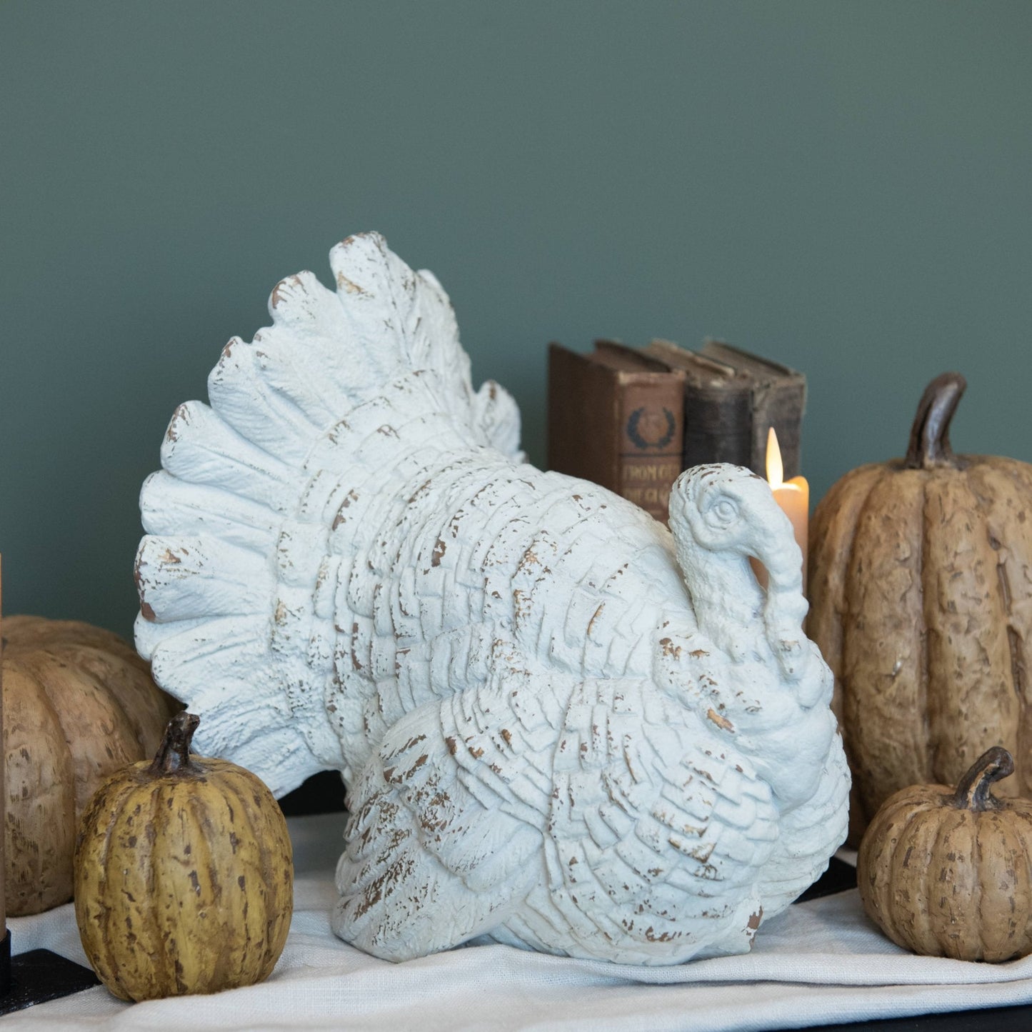 The Harvest Table at Curated Home Decor — vintage-style tabletop turkey with pumpkins, old books and candlelight