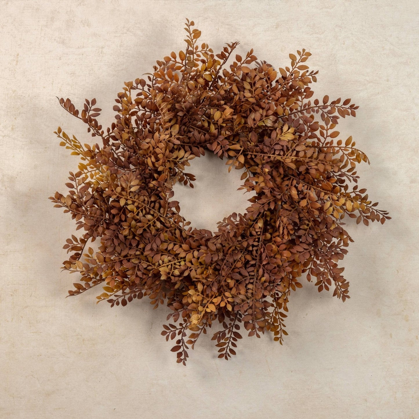 The Fall Collection at Curated Home Decor — autumn ruscus leaf wreath on aged plaster wall