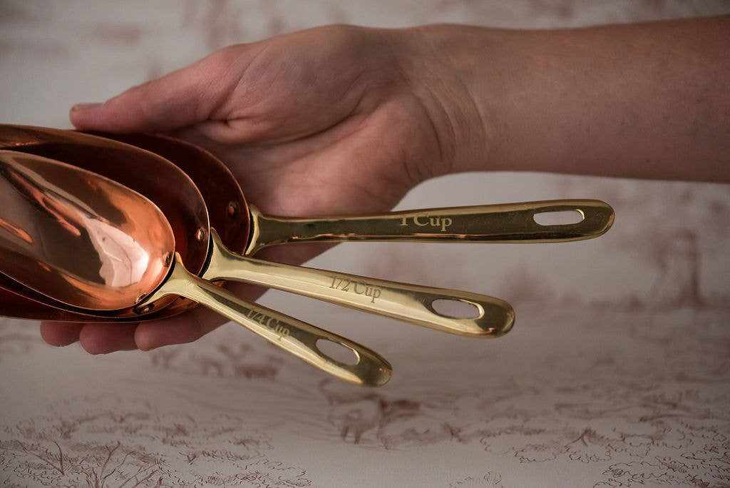 Copper measuring scoops set of three with brass handles for baking and cooking.