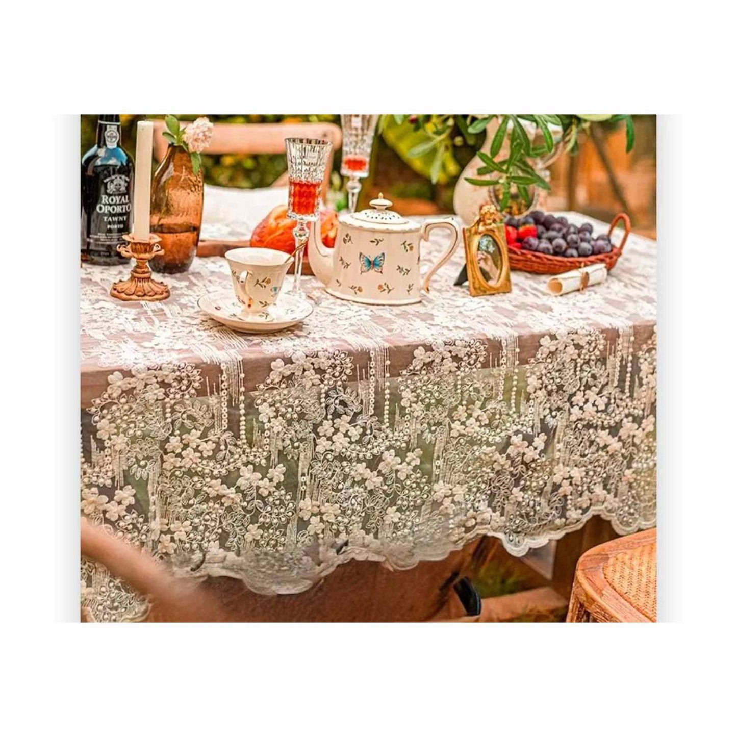 
                  
                    Vintage-style floral lace tablecloth in cream with intricate French lace design on a dining table setting
                  
                