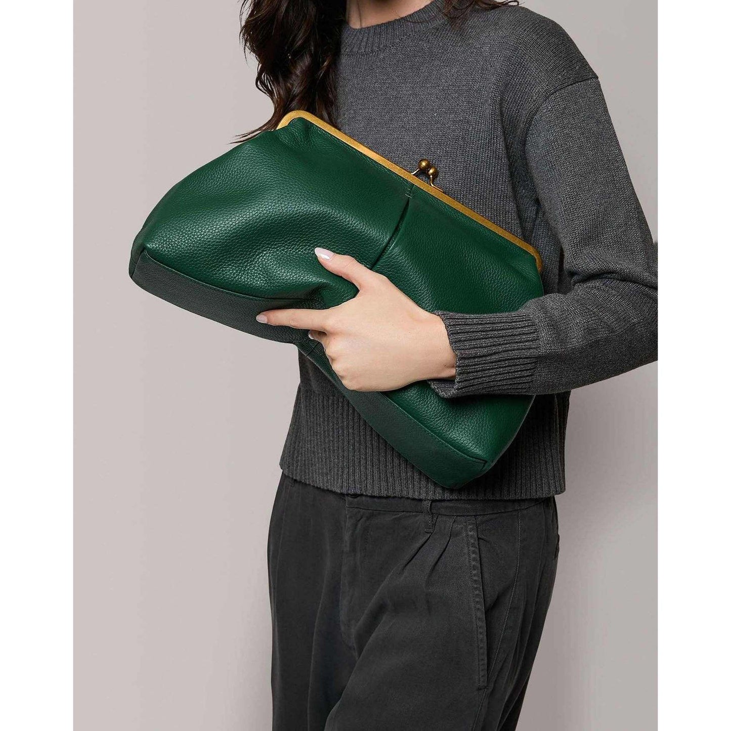 Grace Oversized Clutch deep emerald genuine leather with vintage metal frame clasp held by woman in gray sweater