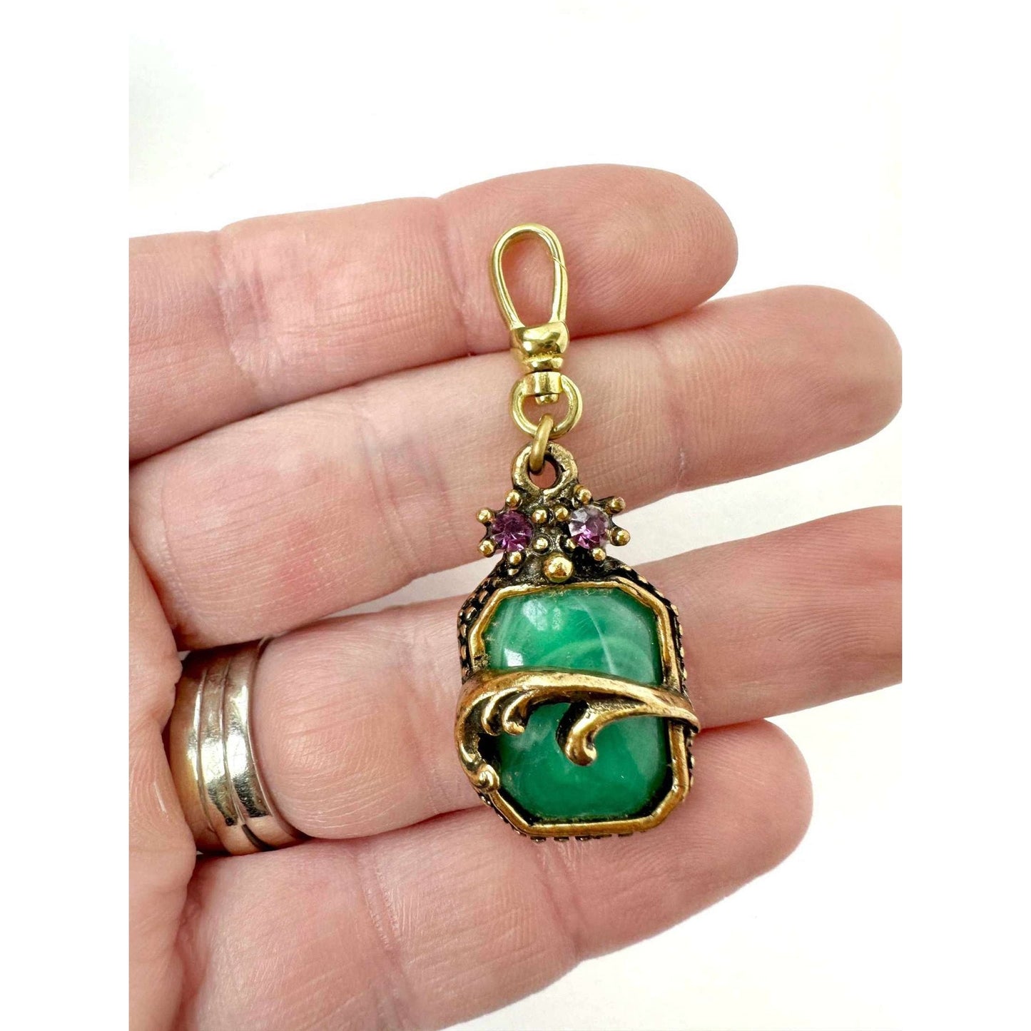 Vintage green cabochon charm in antique brass setting with purple rhinestone accent and swivel clasp