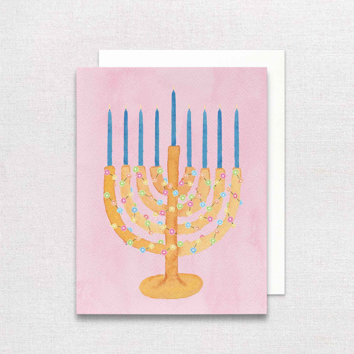 Chrismukkah festive menorah greeting card with hand-painted menorah, blue candles, colorful string lights on pink background
