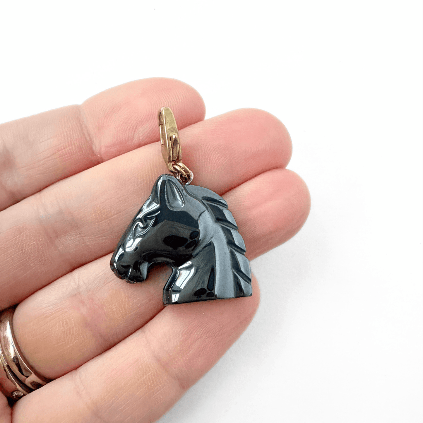 Vintage carved hematite horse head charm with brass clasp and reflective gunmetal finish