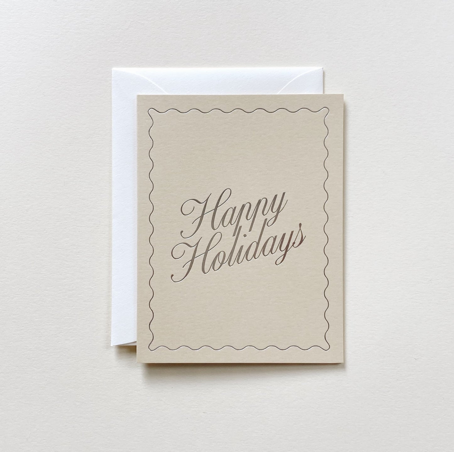 Happy Holidays No. 25 sand-colored folded card with metallic silver foil stamp and natural envelope