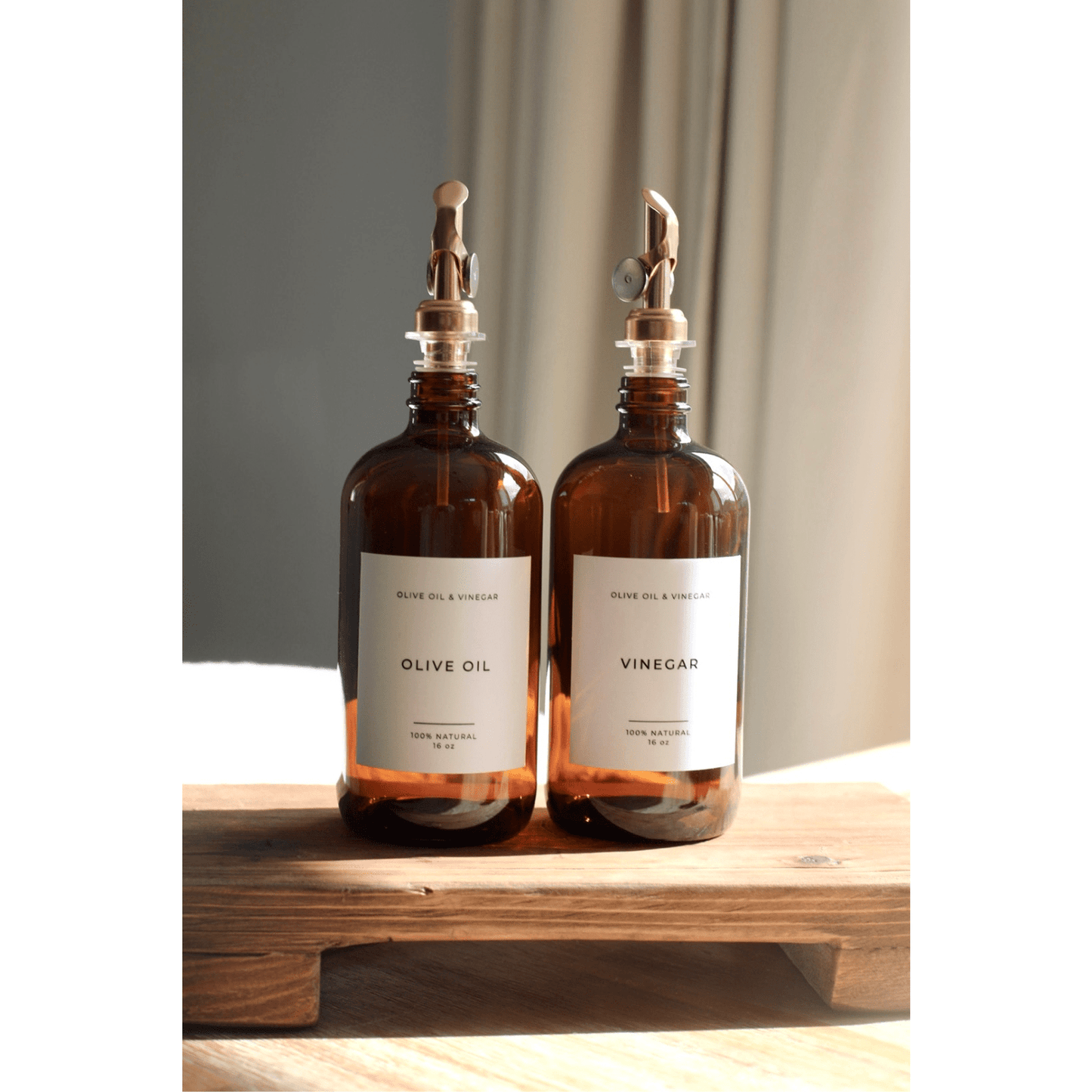 Amber vinegar refillable glass dispenser bottle with stainless steel pour spout on wooden stand