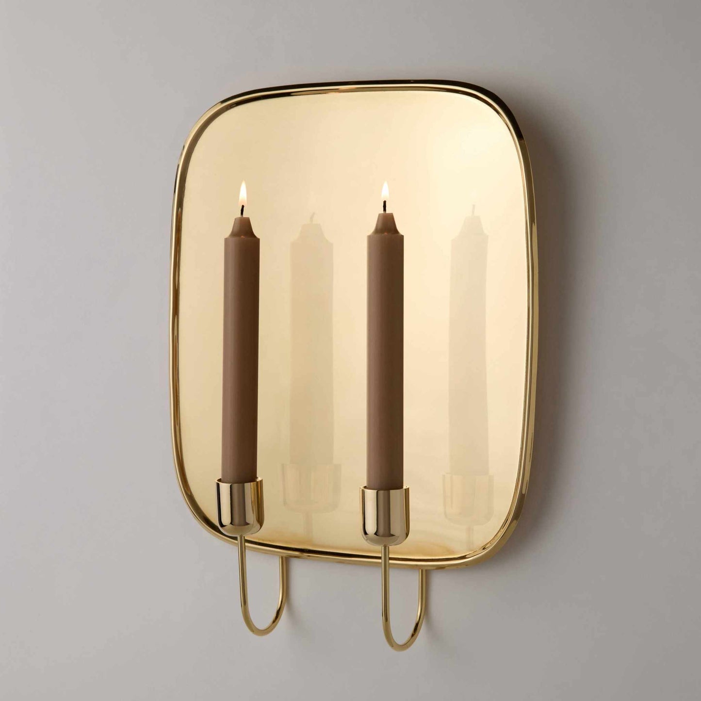 Uma Brass Wall Sconce unlacquered solid brass mid-century Scandinavian design with two lit candles