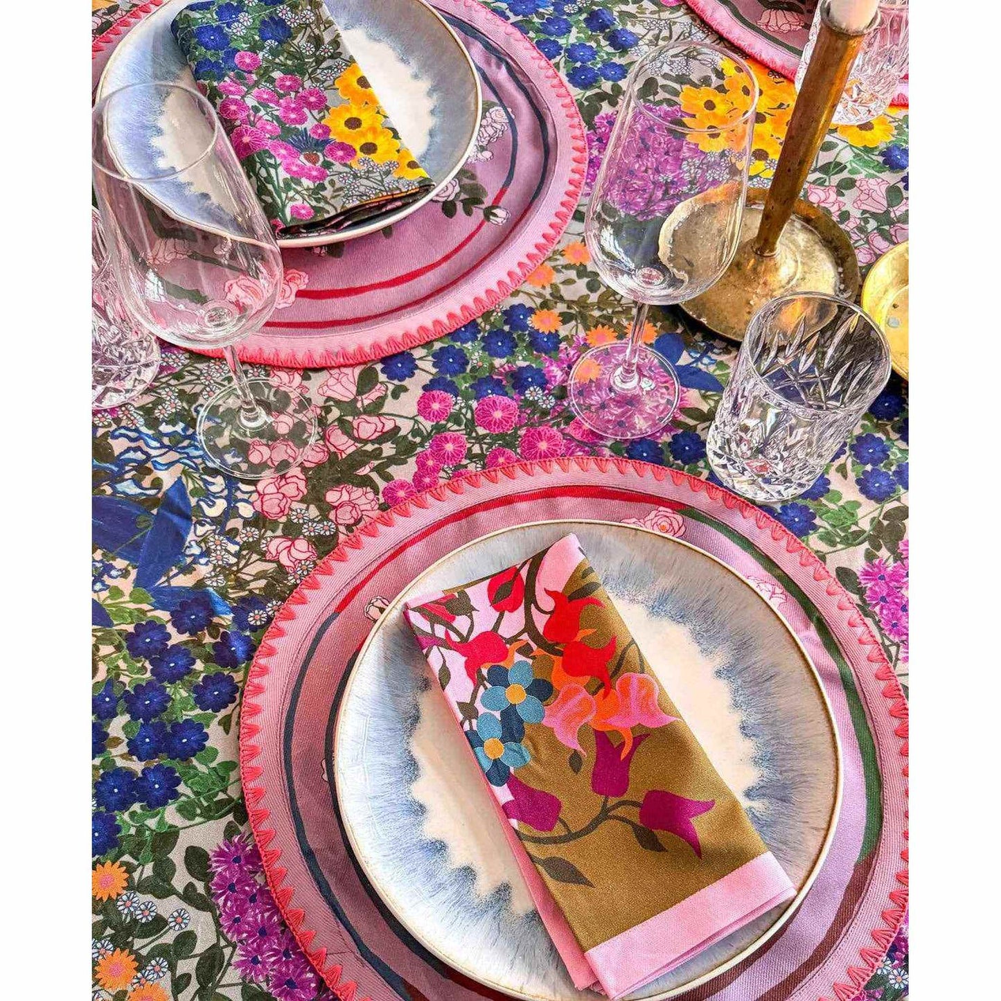 Garden Bloom Cotton Napkins with multicolor floral print and pink border on olive green background