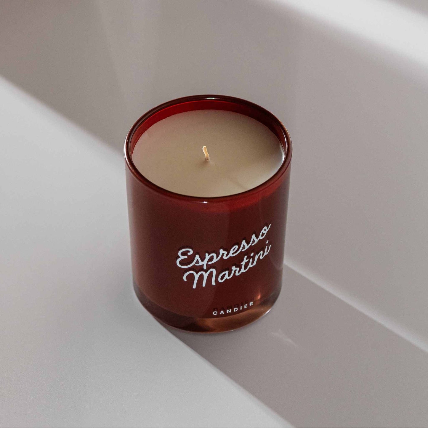 Espresso Martini Candle in a red glass jar with white lettering, unlit wick visible