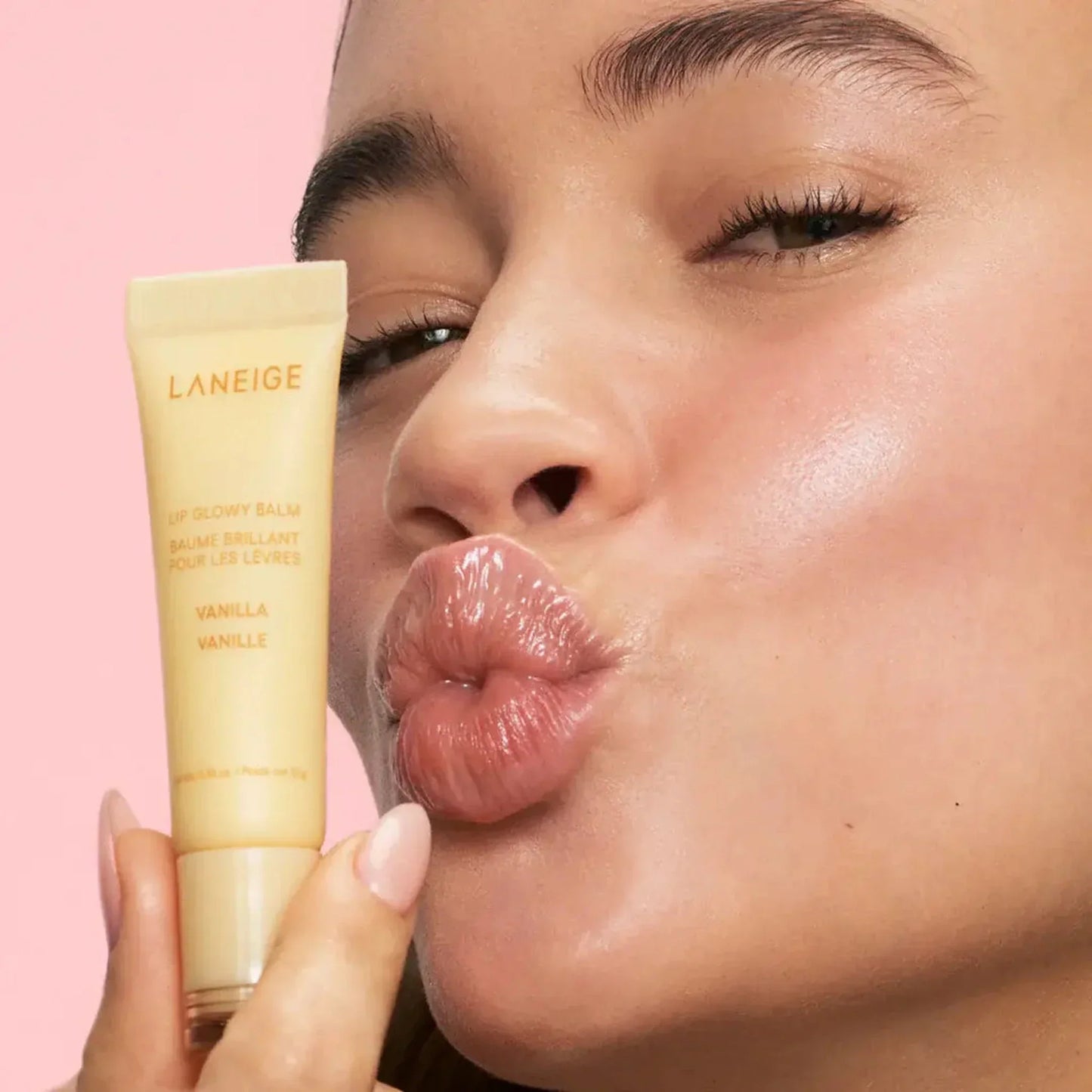 Woman holding LANEIGE S'more Kisses Set Vanilla Lip Glowy Balm with glossy hydrated lips