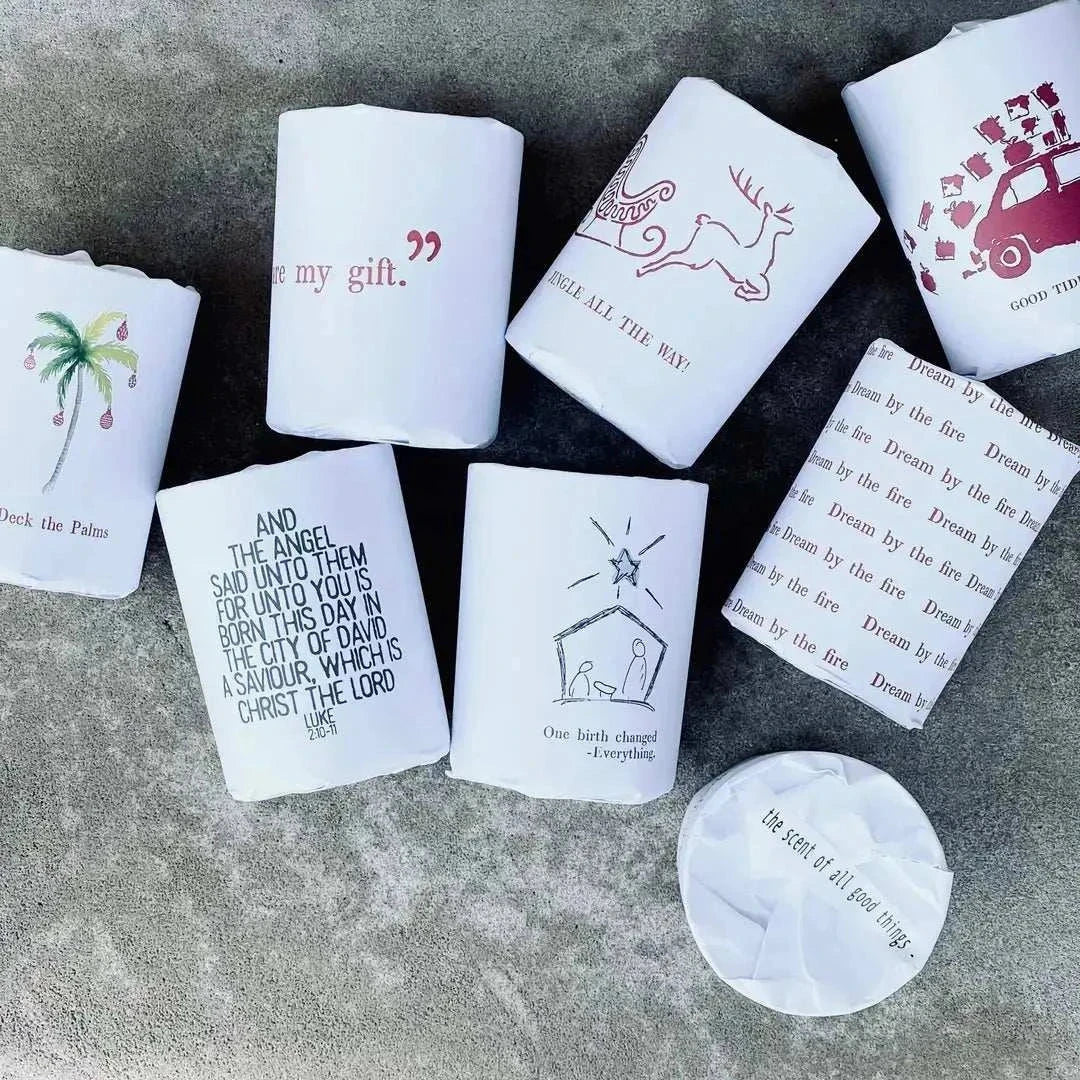 10oz Christmas Candle with holiday paper wrap and hand-drawn designs featuring festive messages and symbols