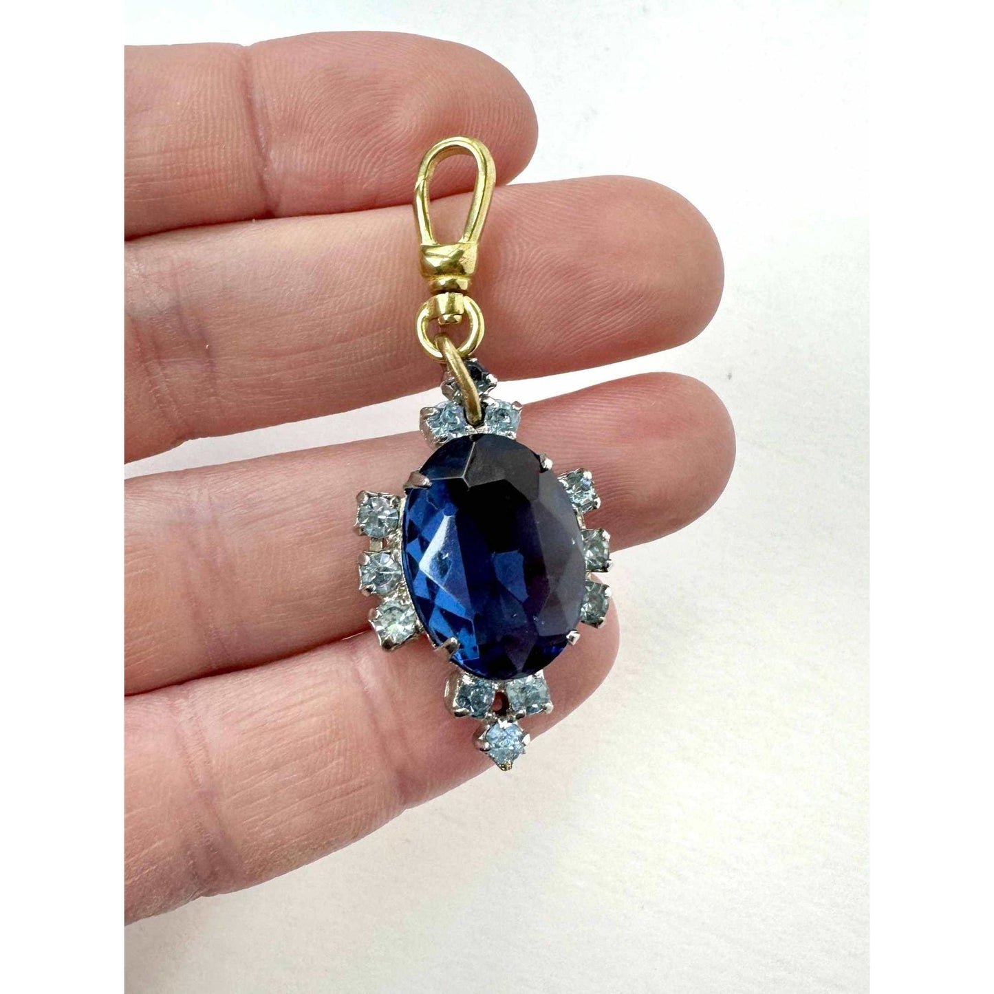 Vintage sapphire blue oval rhinestone charm with raw brass swivel clasp and light blue stones