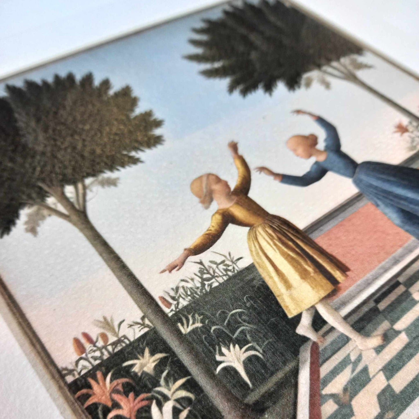 Close-up of The Orange Tree framed art print featuring two women dancing under tall trees in a Mediterranean garden setting