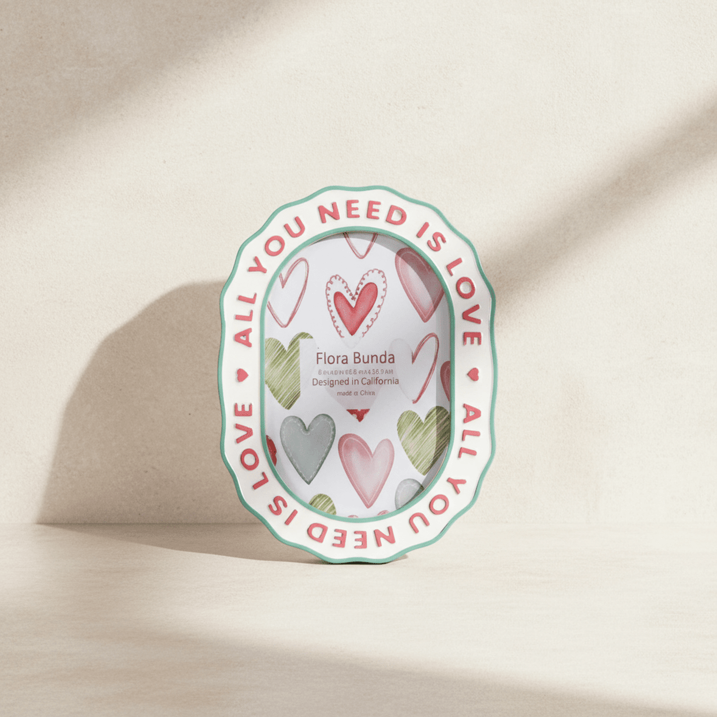
                  
                    Ceramic heart photo frame with colorful watercolor hearts and raised All You Need Is Love lettering
                  
                