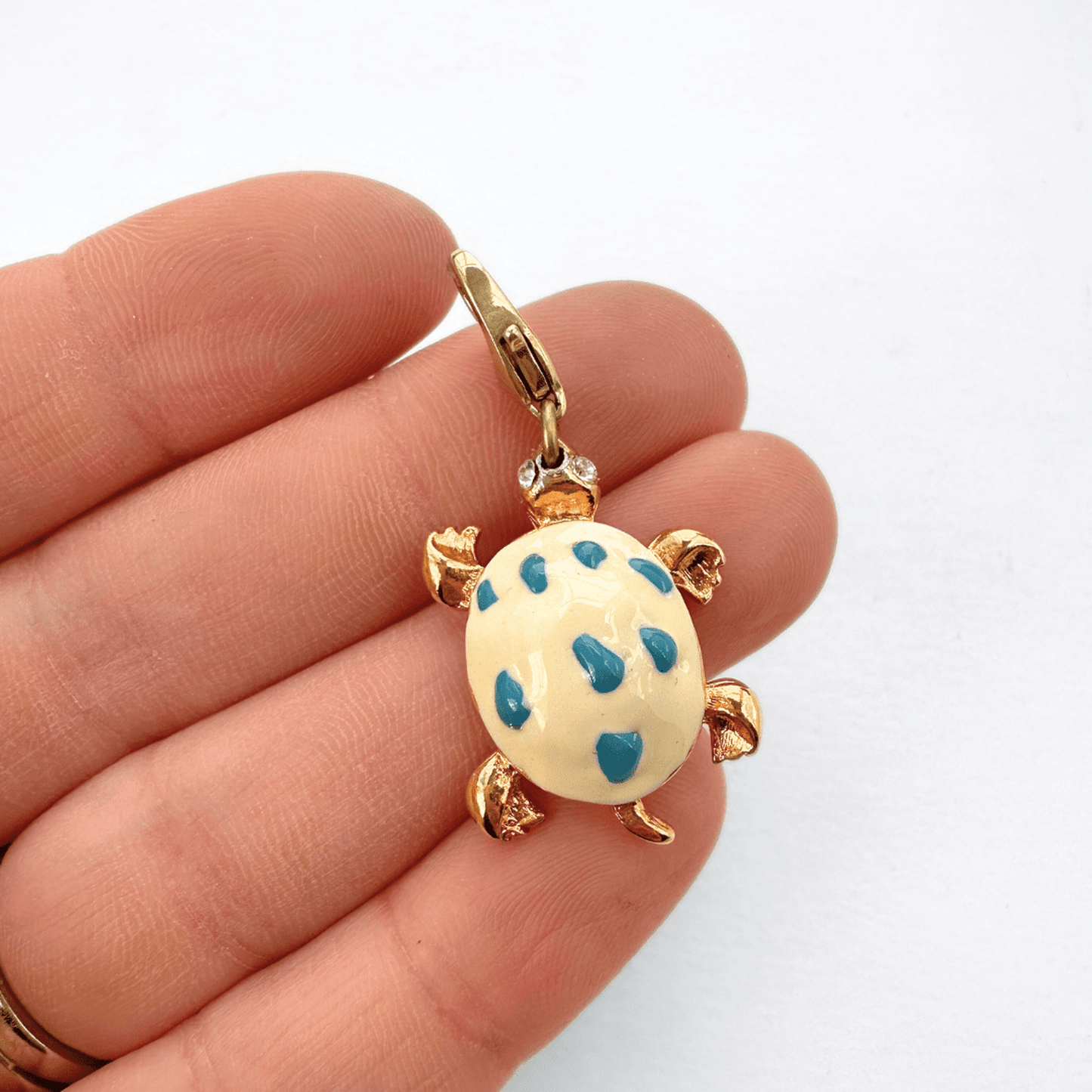 Vintage white and blue enamel turtle charm with rhinestone eyes and brass clasp