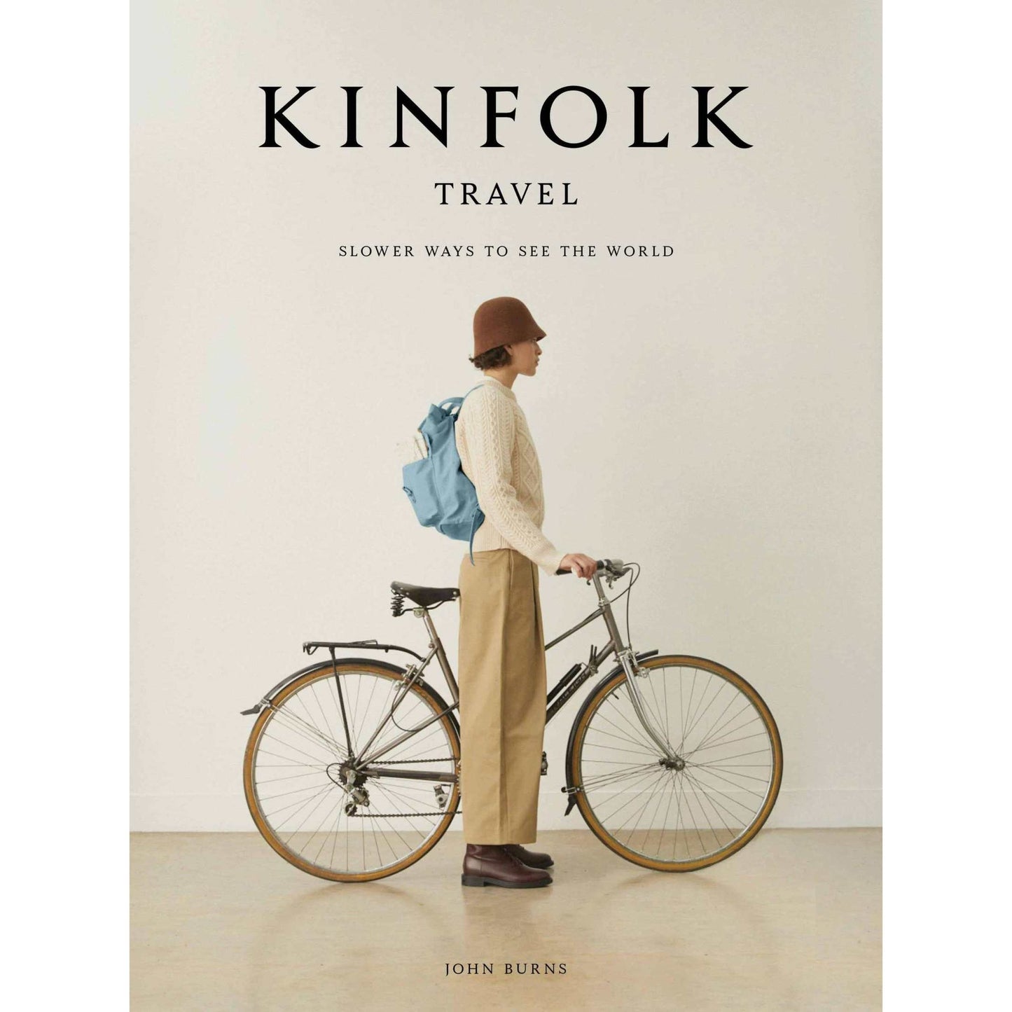 Kinfolk Travel book cover featuring a person with a bicycle promoting mindful slow travel experiences