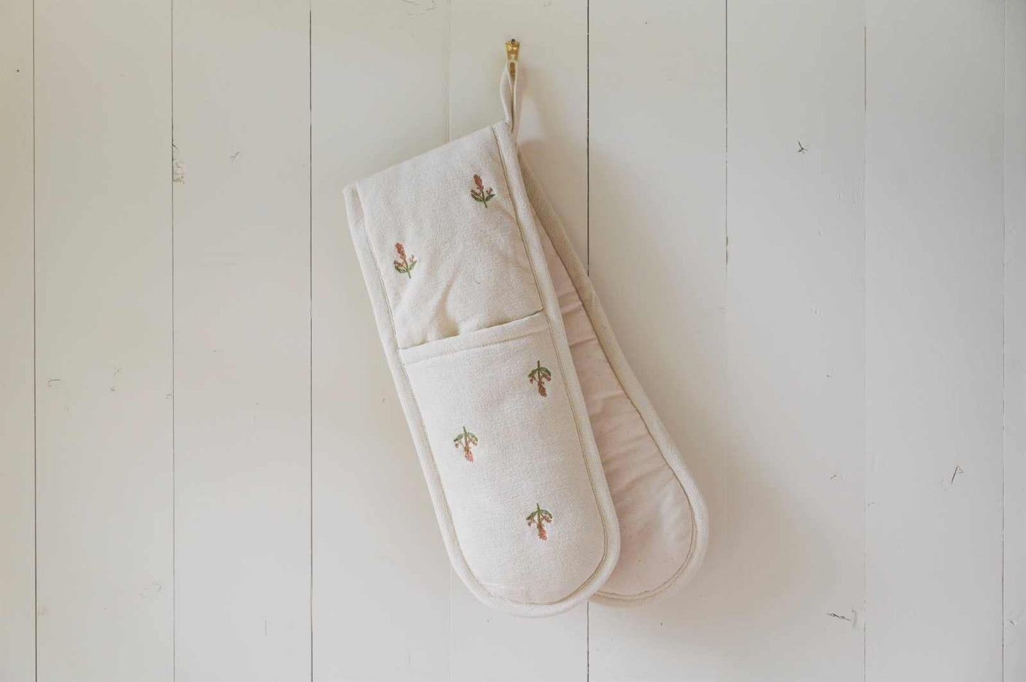 Flora Double Oven Mitt with embroidered florals on cream fabric, padded pockets, and hanging loop for kitchen display