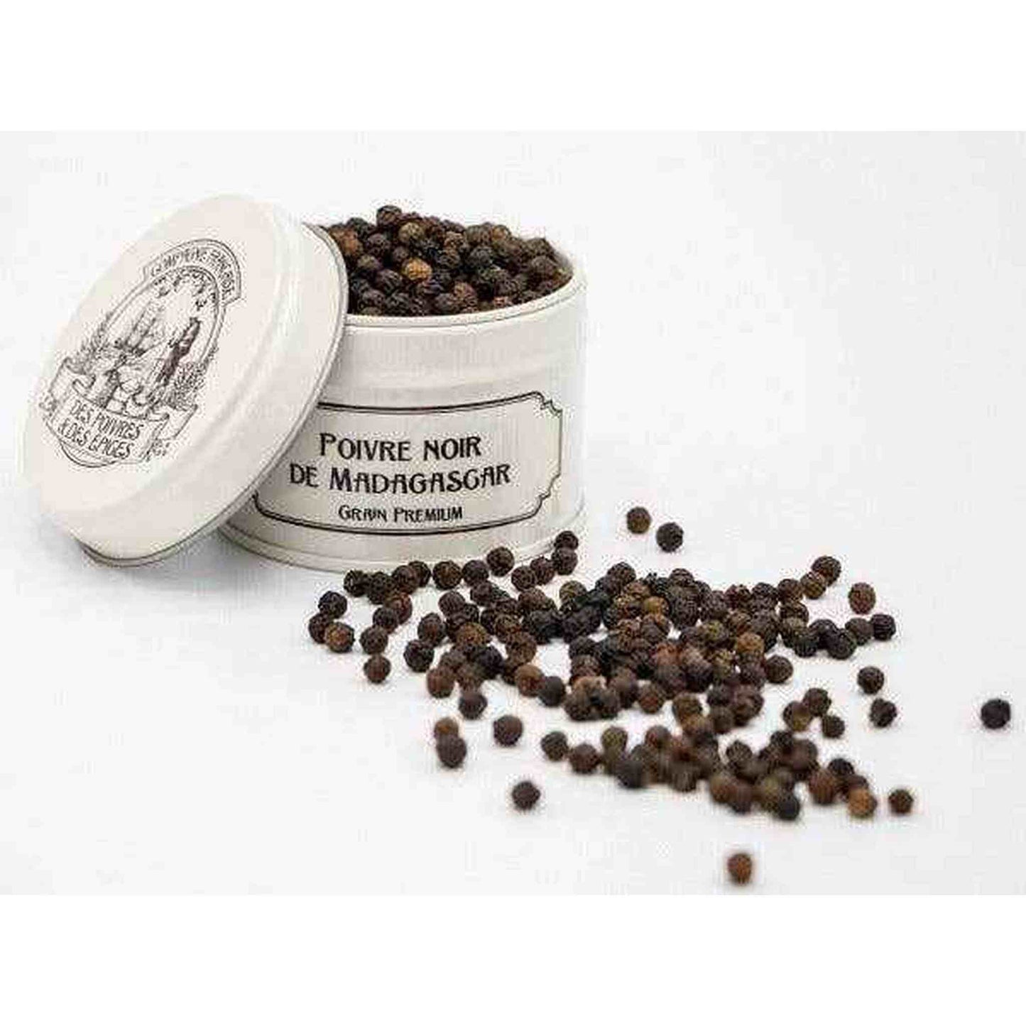Black pepper from Madagascar in a white tin with scattered peppercorns around