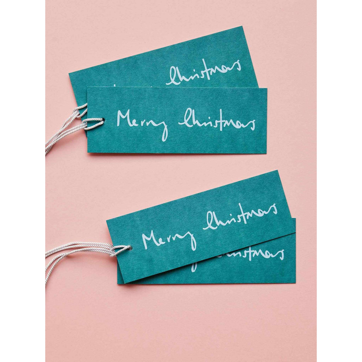 
                  
                    Set of 8 teal Merry Christmas gift tags on FSC-certified card with white text and attached strings
                  
                