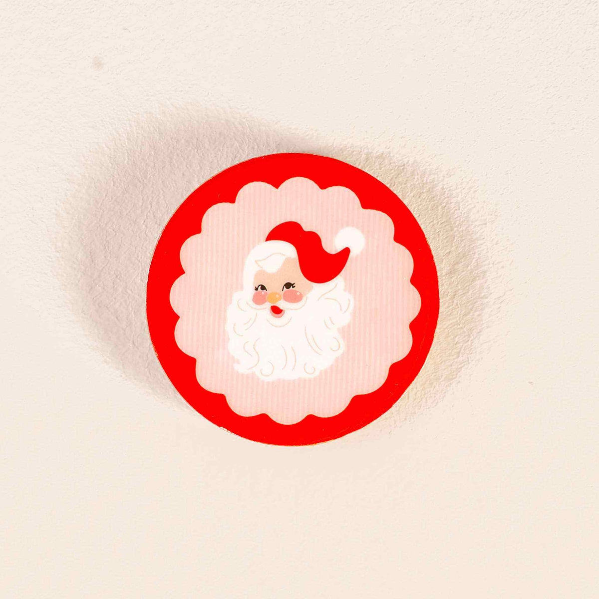 
                  
                    Wood enamel coaster with holly jolly Santa design on wood surface
                  
                