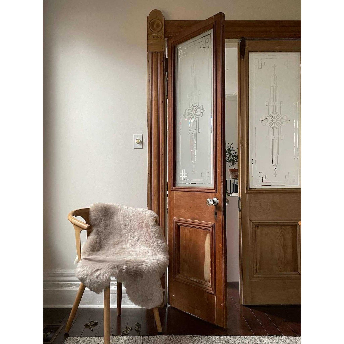 Shorn Nude Icelandic Sheepskin throw rug draped over wooden chair in cozy room