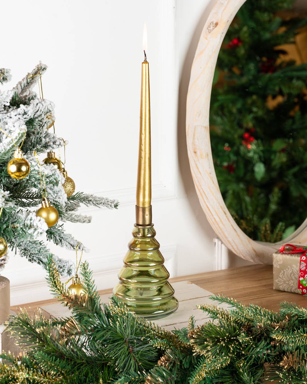 Green glass Tinsel Tree Candleholder with gold taper candle on wooden table holiday decor