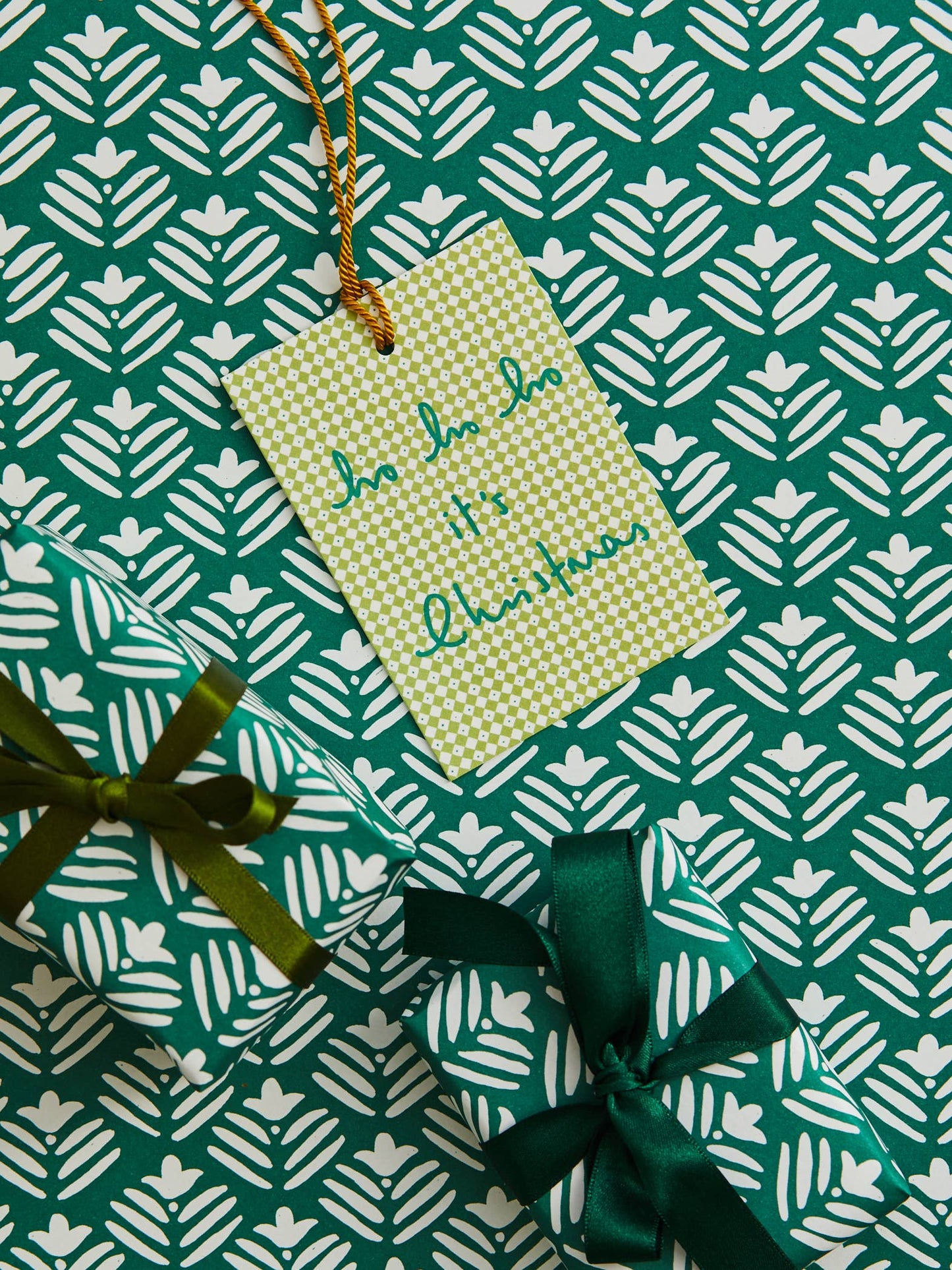 HO HO Diamond Green gift tag on matching green patterned wrapping paper with two wrapped presents tied with green ribbons