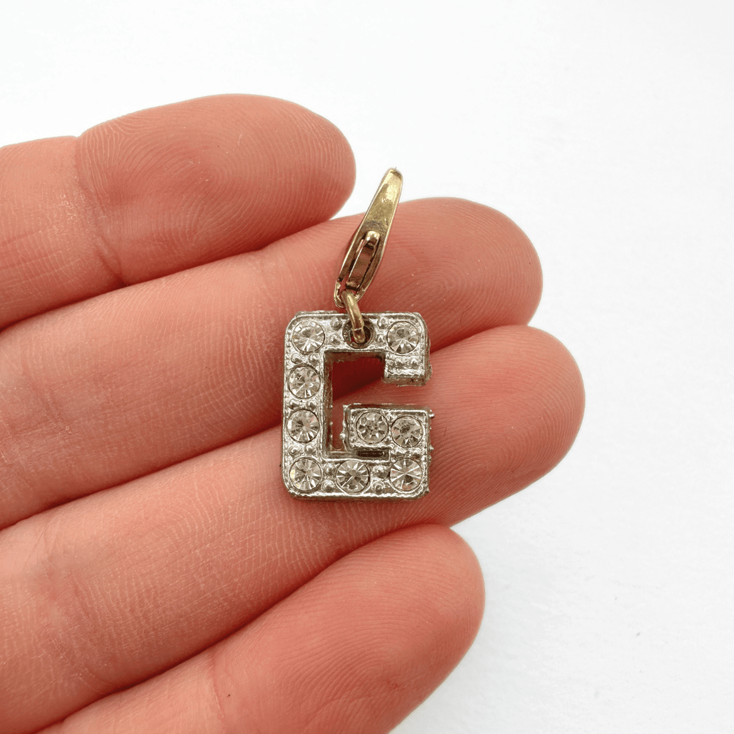 Small vintage clear rhinestone letter G charm with silver tone setting and brass clasp
