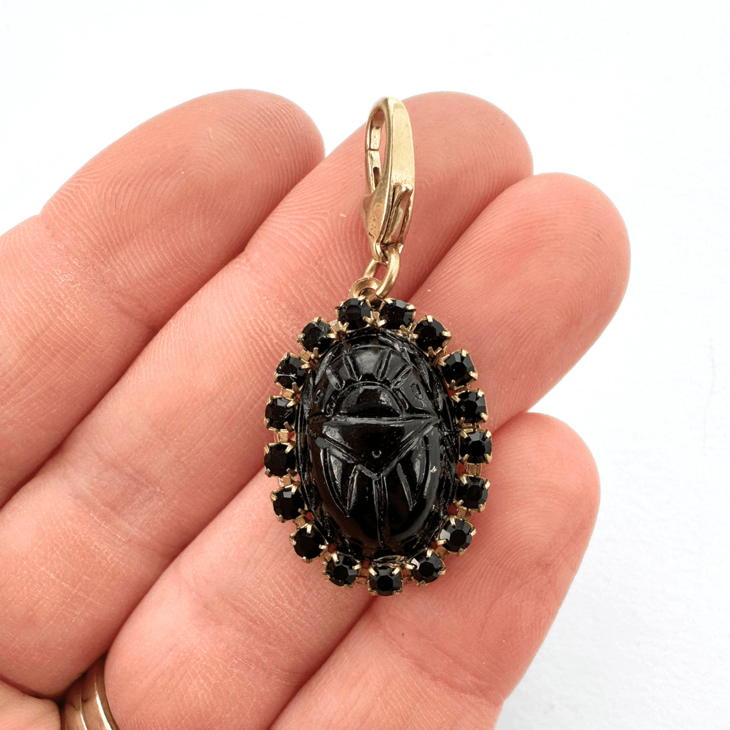 Vintage black glass oval scarab charm with rhinestone border and brass clasp