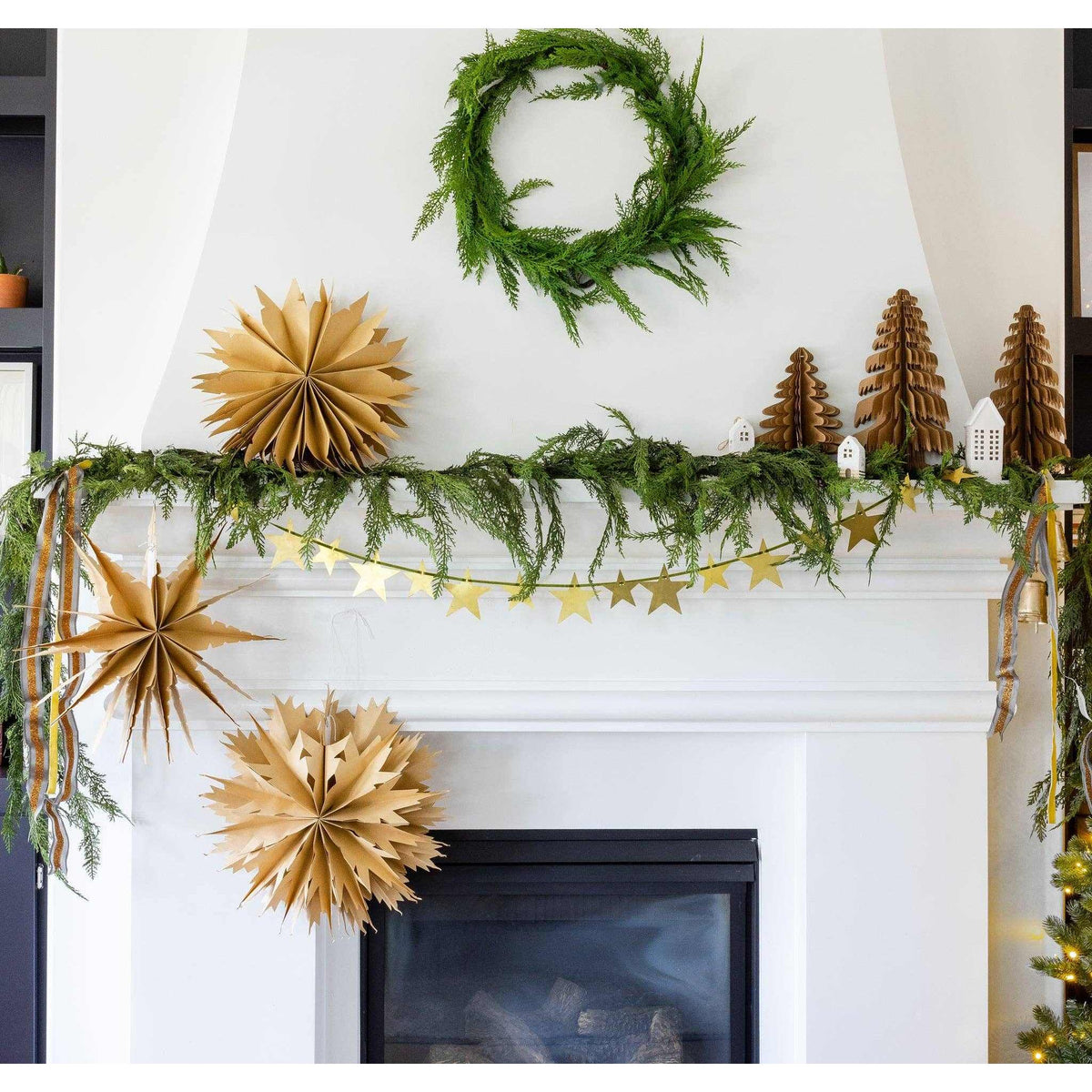 
                  
                    Christmas Memories medium 11-inch kraft paper accordion tree decor on mantel with festive greenery and star garland
                  
                