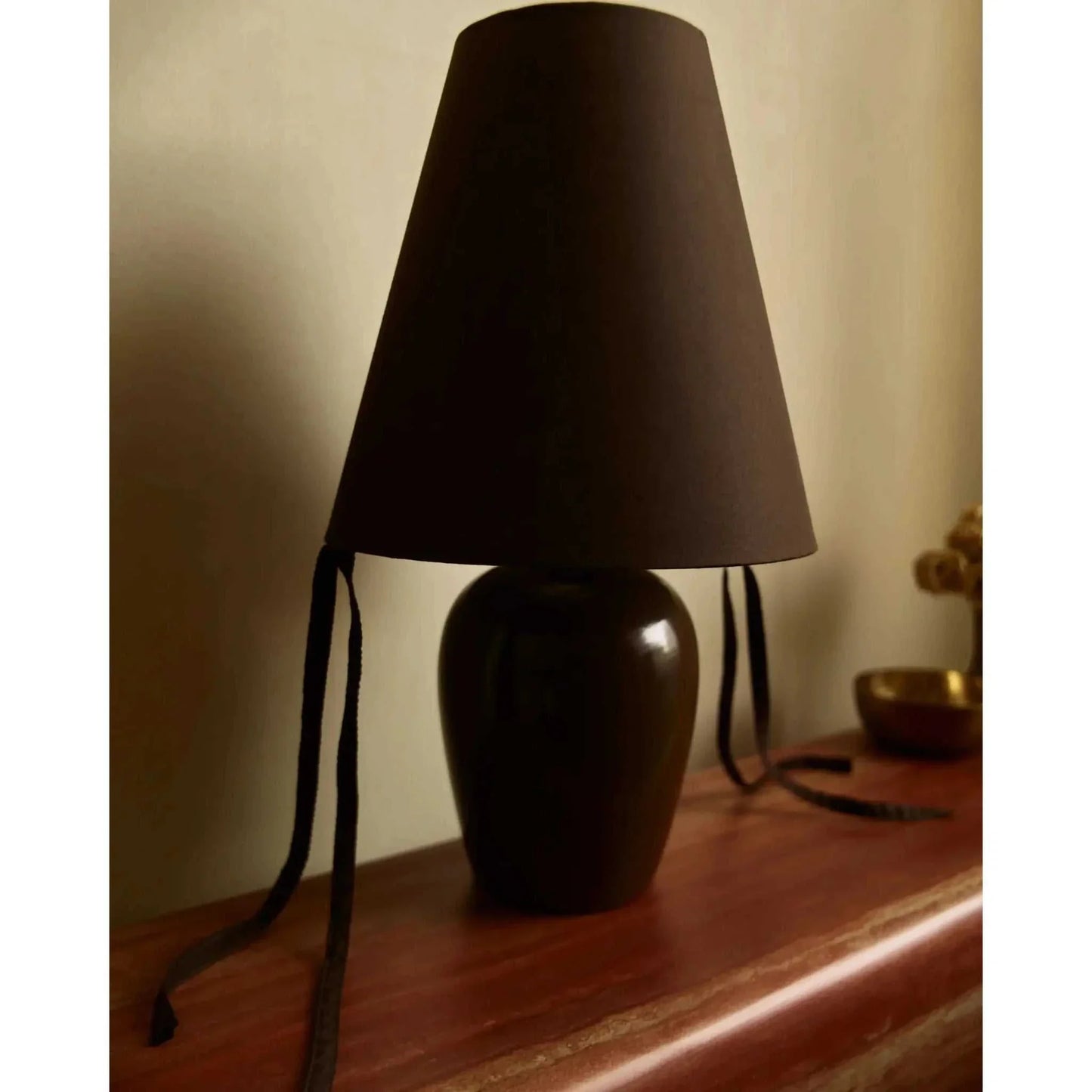 Appenzell Grande Atelier table lamp with sculptural form and black shade on wooden surface