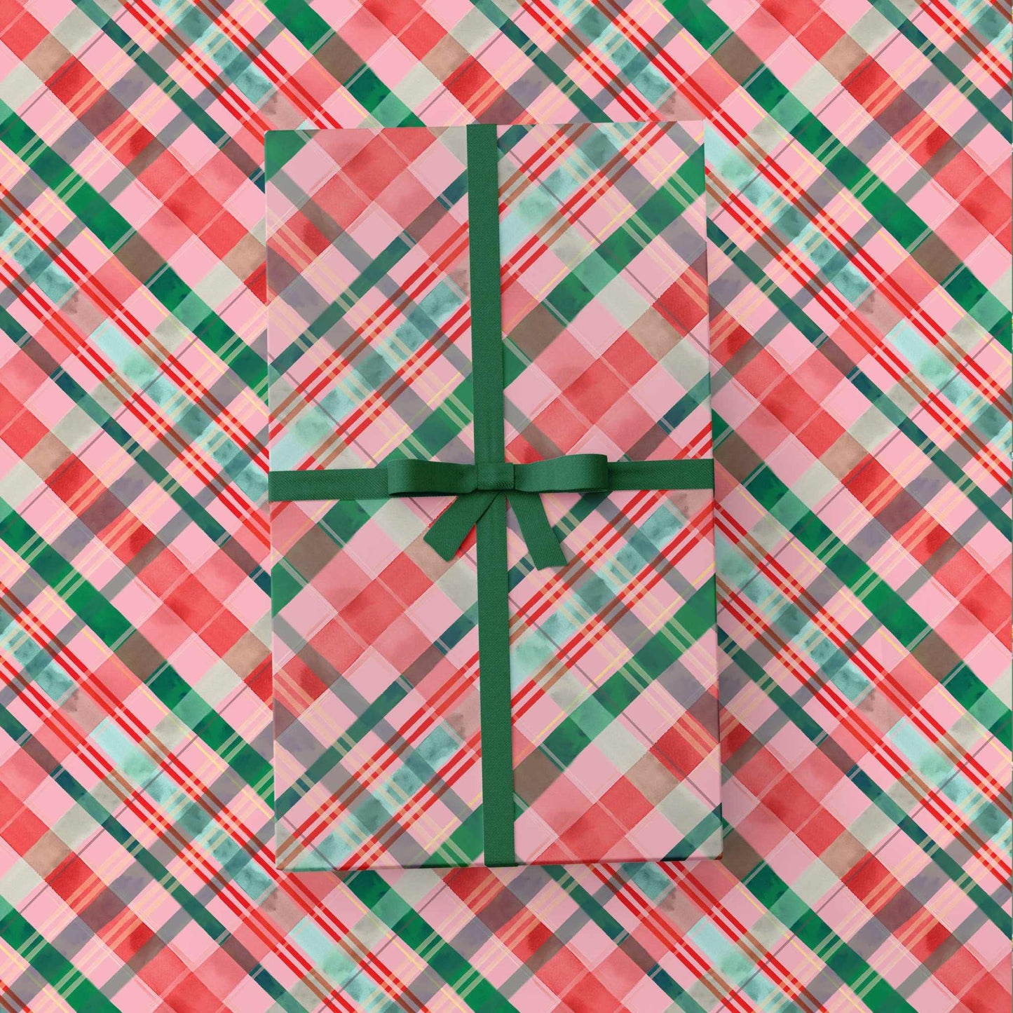 Merry Plaid Wrapping Paper with red green and pink festive plaid pattern and green ribbon bow on gift box