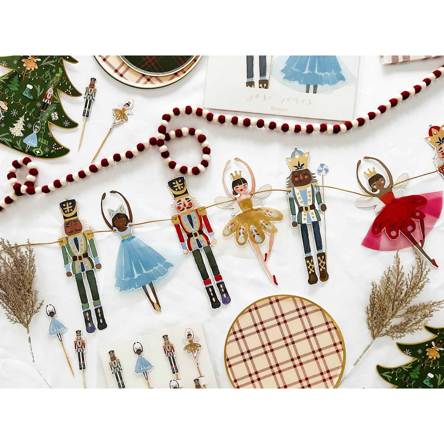 Nutcracker Christmas banner with ballerina and nutcracker figures hanging on gold string with metallic foil accents