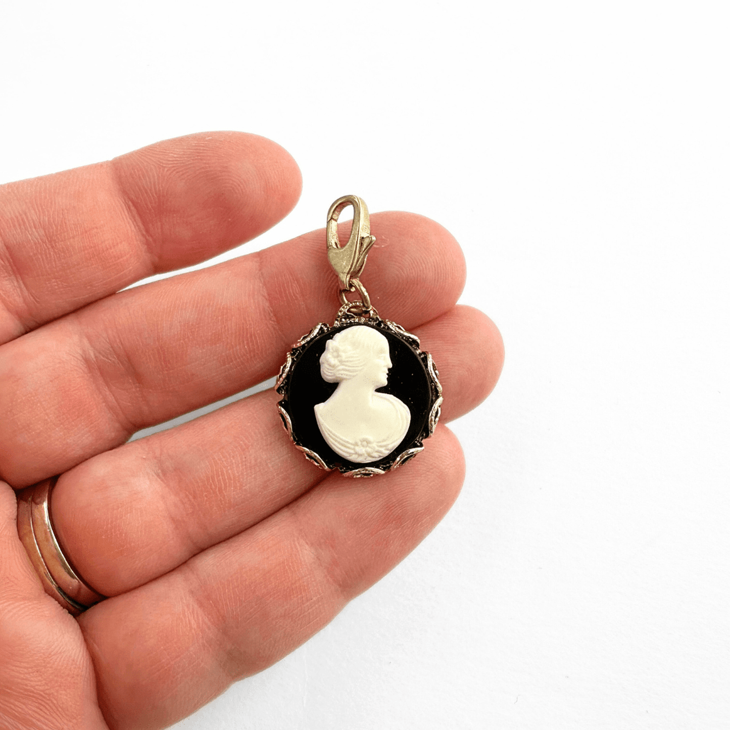 Vintage black and white acrylic cameo charm with gold lace-edge and brass clasp