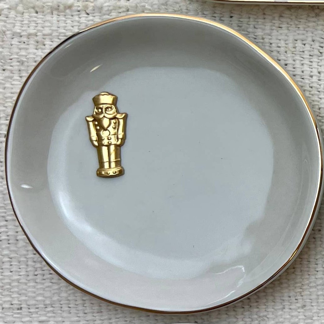 Christmas round gold accent dish in grey with gold nutcracker detail and rim, 4-inch diameter trinket dish