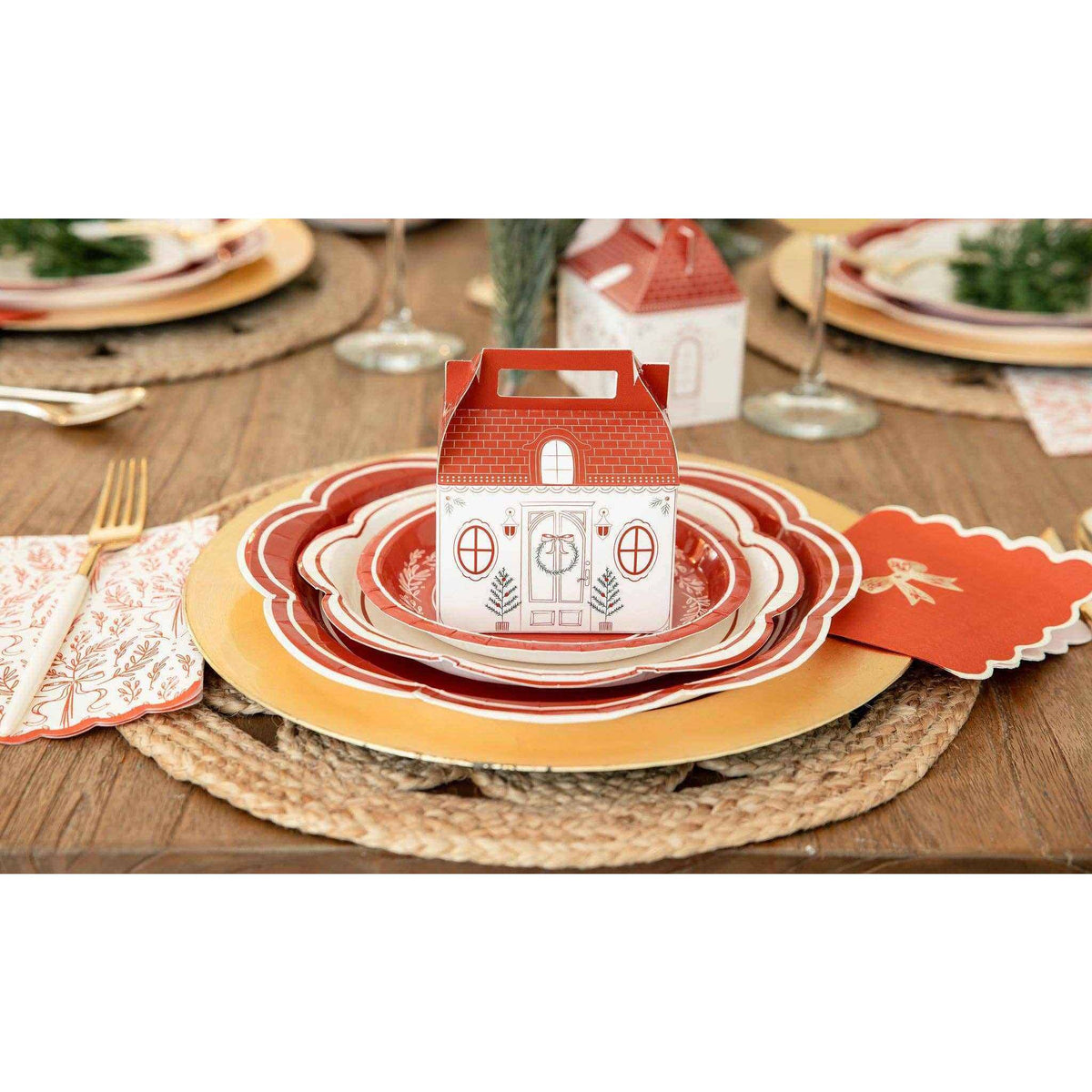 
                  
                    Red and gold bow cocktail napkin with holiday table setting and decorative plates
                  
                