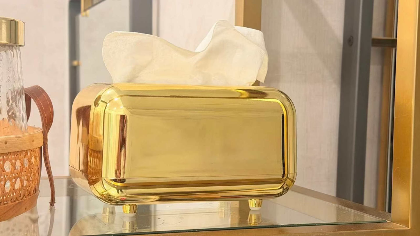 
                  
                    Modern gold footed napkin holder with high-gloss finish and rounded rectangular shape
                  
                