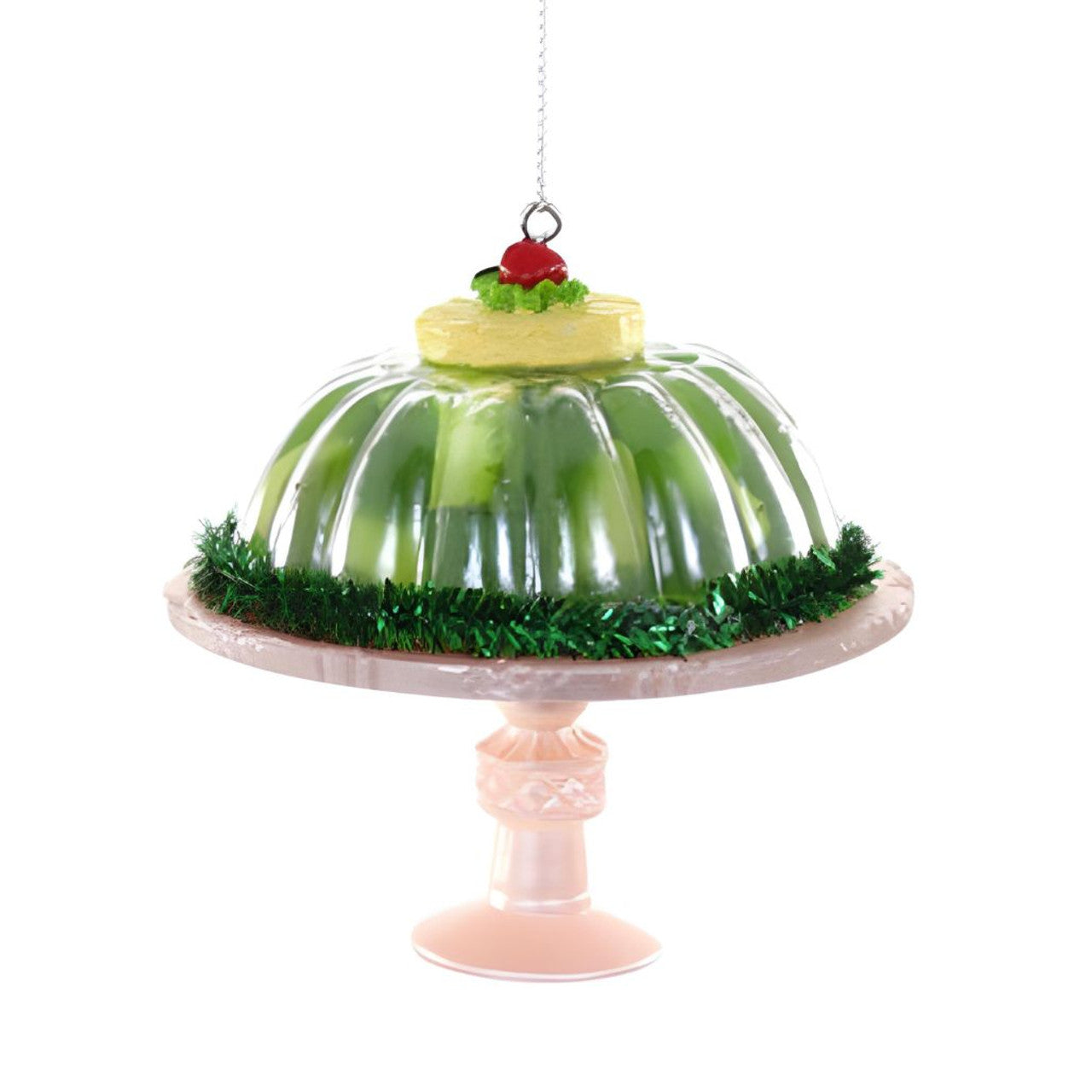 Decorative jelly mold with green jelly on a stand against a white background