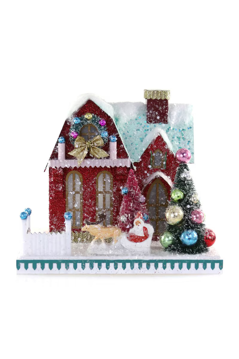 Handcrafted Santa Ranch Christmas house decoration with snowy roof, festive red exterior, decorated tree, and Santa in sleigh by Cody Foster
