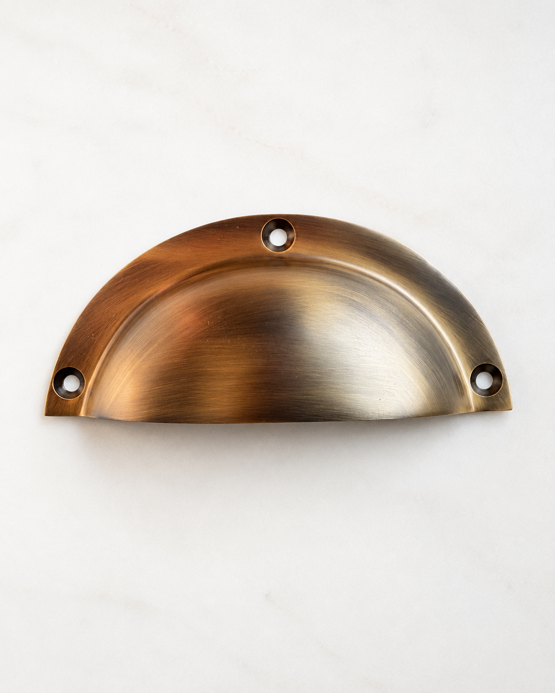 Antique brass half-moon cabinet bin pull with three mounting holes, approximately five inches wide.