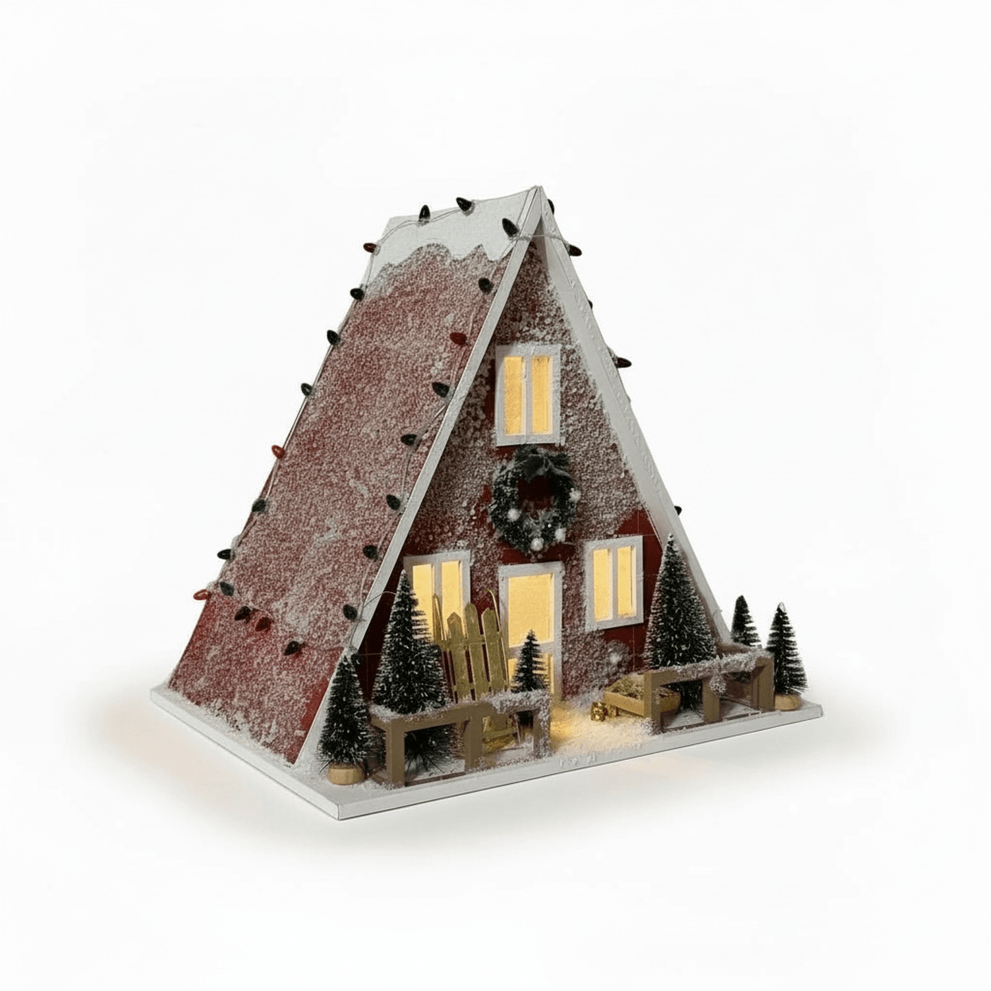 A-Frame winter cabin holiday decor with light-up windows, snow-dusted red siding, bottle-brush trees, wreath, and sled, battery-operated for indoor display.