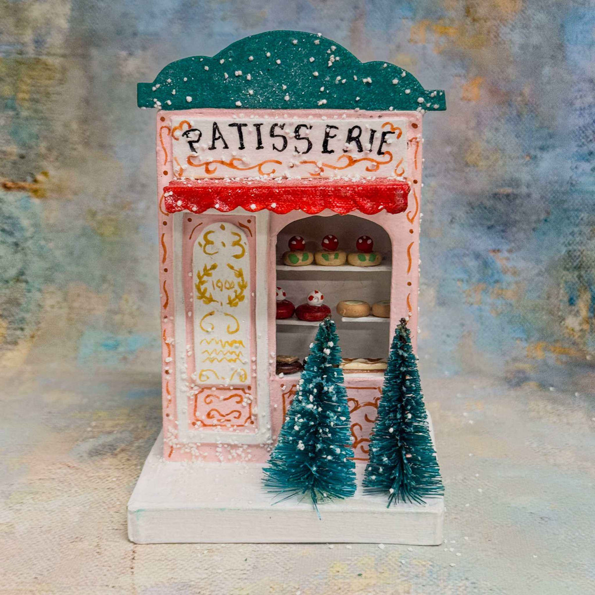 
                  
                    European village shop patisserie holiday paper house ornament with Christmas trees
                  
                