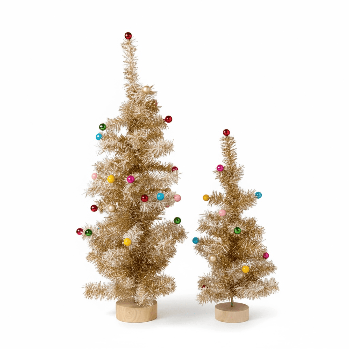 Holiday decorated gold tinsel trees with snowy white tips and colorful ornaments on light wood bases