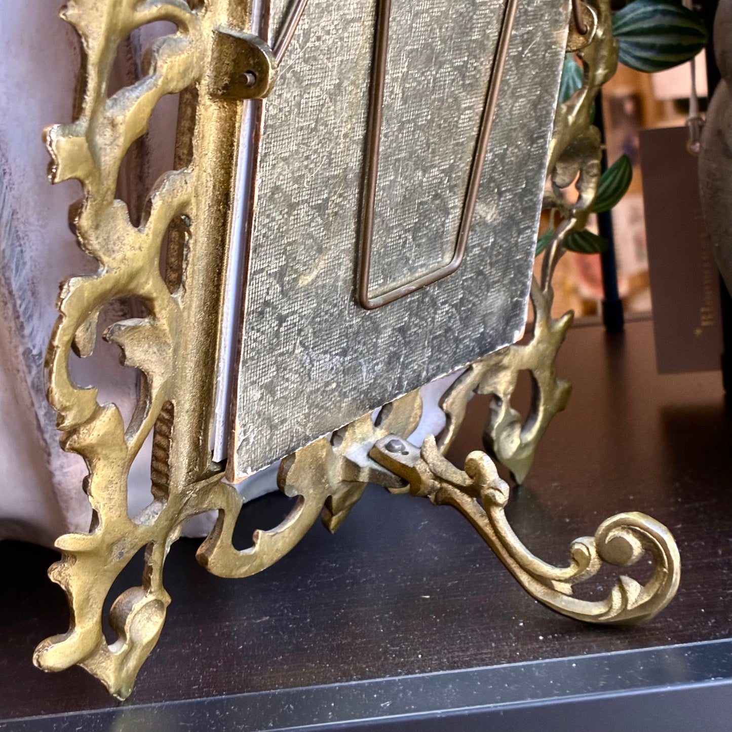 
                  
                    Gold stand attached to gold photo frame
                  
                