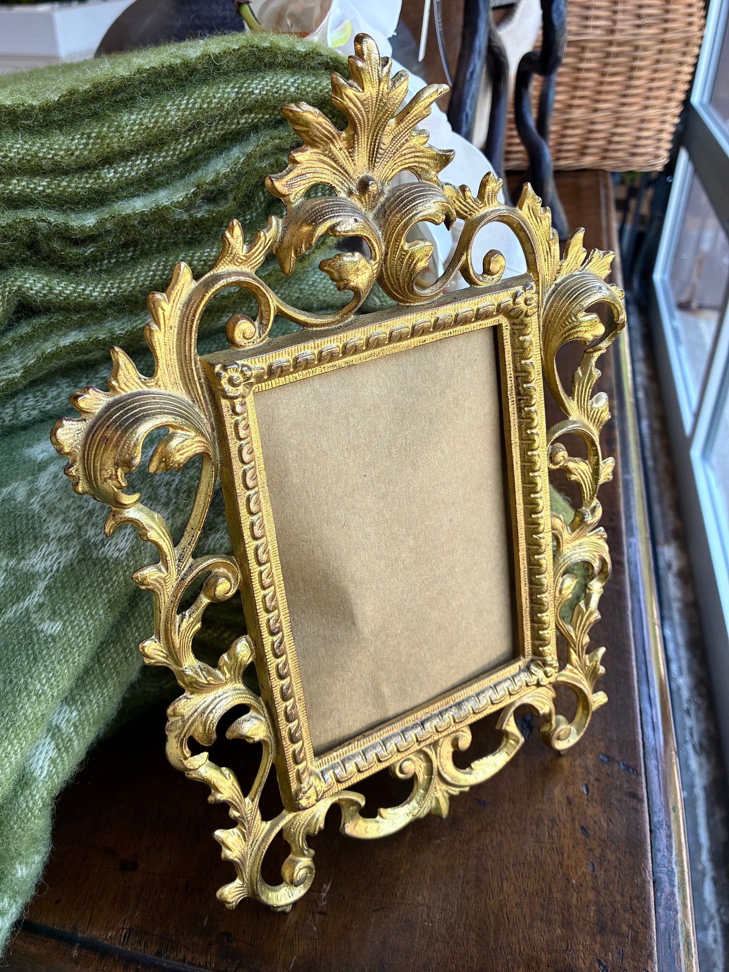 
                  
                    Empty gold frame sitting on wood surface
                  
                