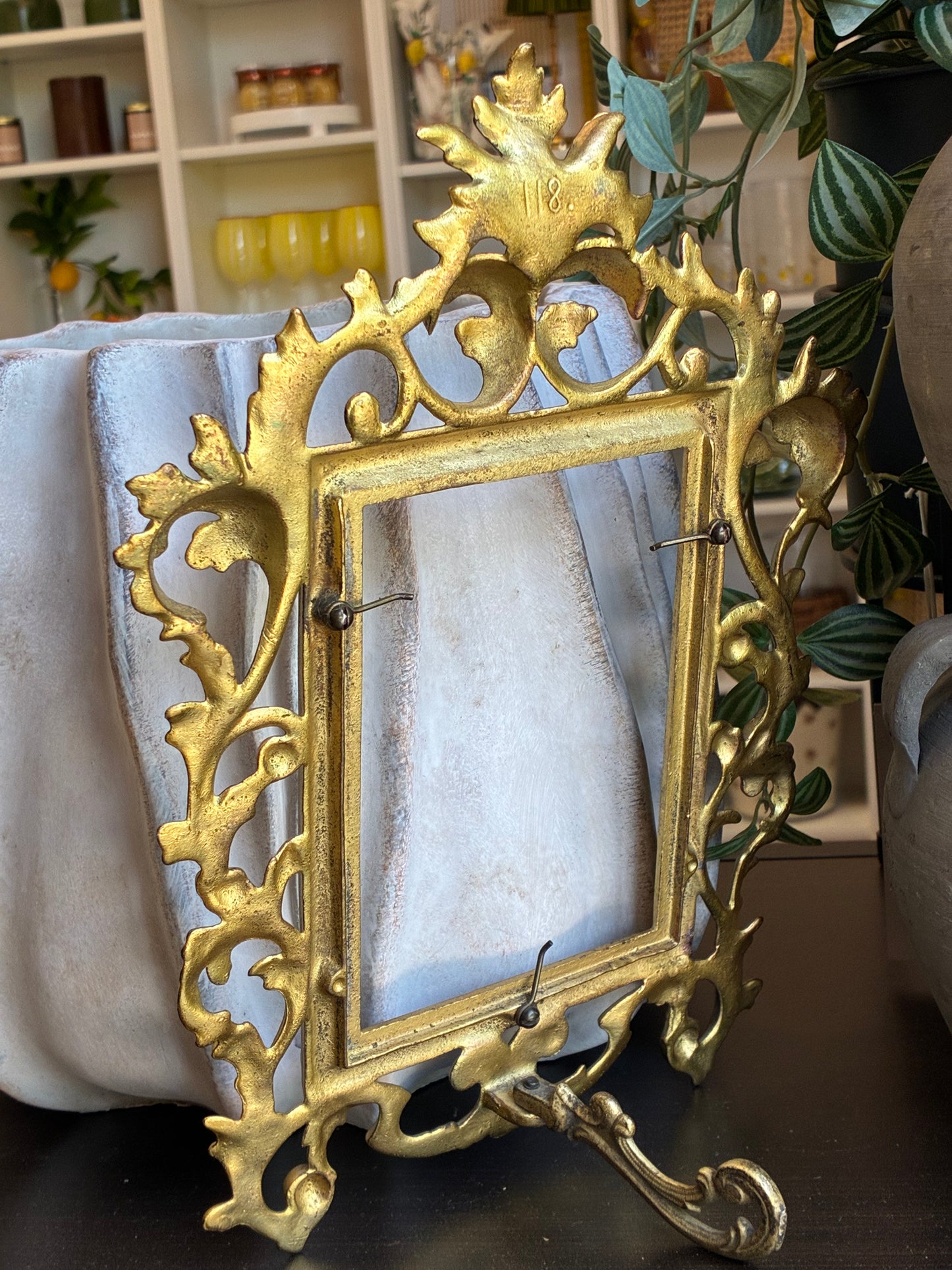 
                  
                    Back of gold picture frame, no art inside, shows simple easel style stand
                  
                