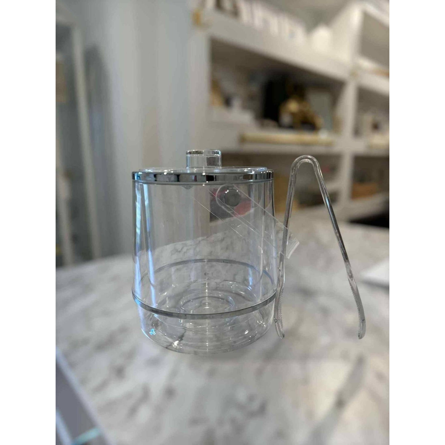 Vintage Lucite ice bucket with lid handle and tongs on marble countertop