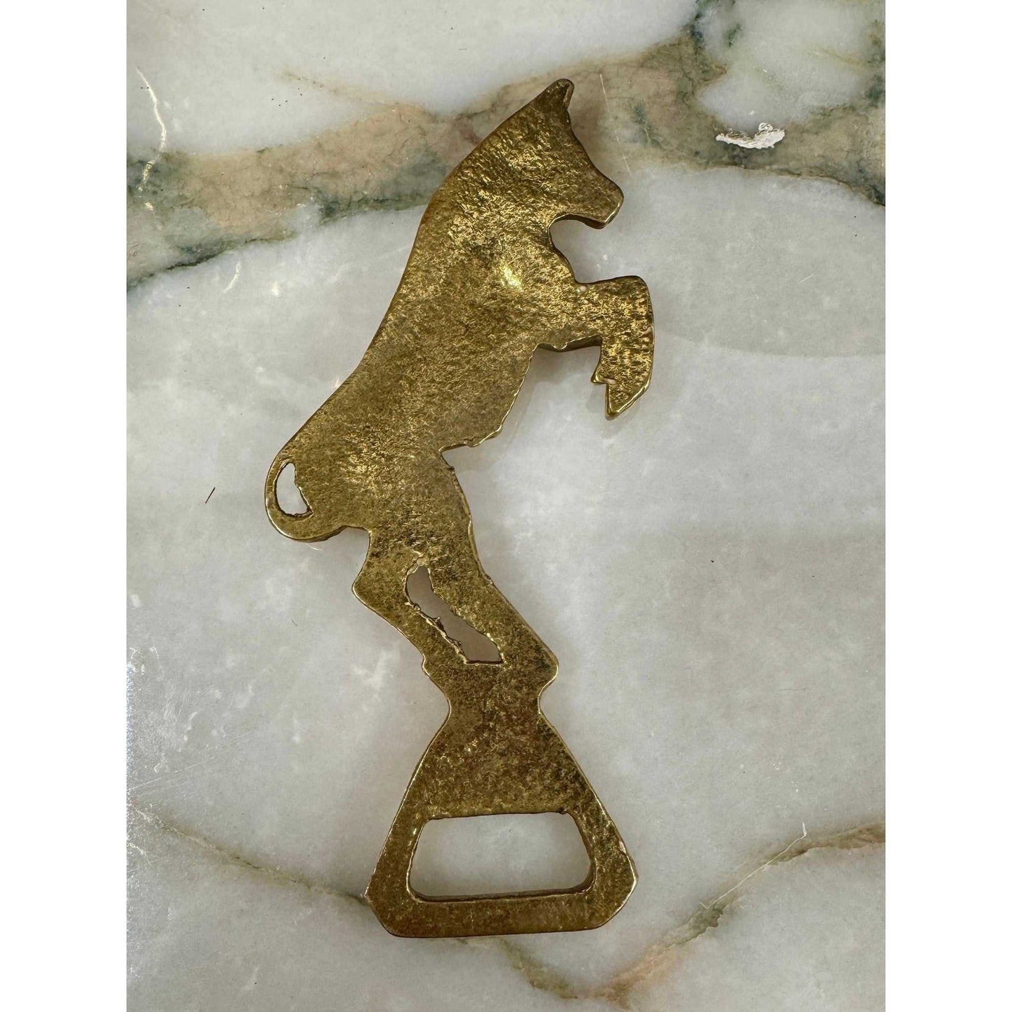 Vintage brass bull bottle opener with rearing design and aged patina