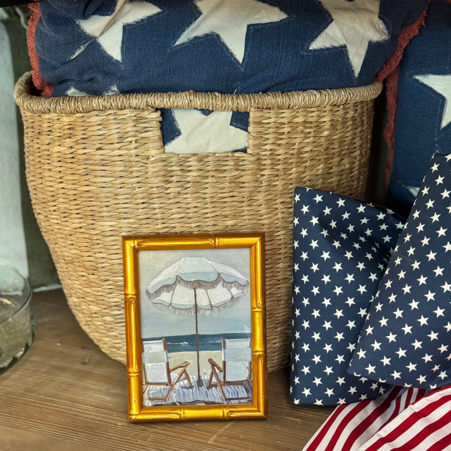 
                  
                    Basket with American flag-themed items including a small framed picture and fabric.
                  
                