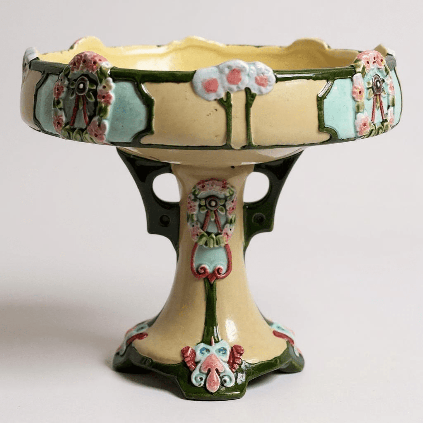 Antique Majolica pedestal compote with raised floral wreaths and pastel dappled glaze circa 1890–1910